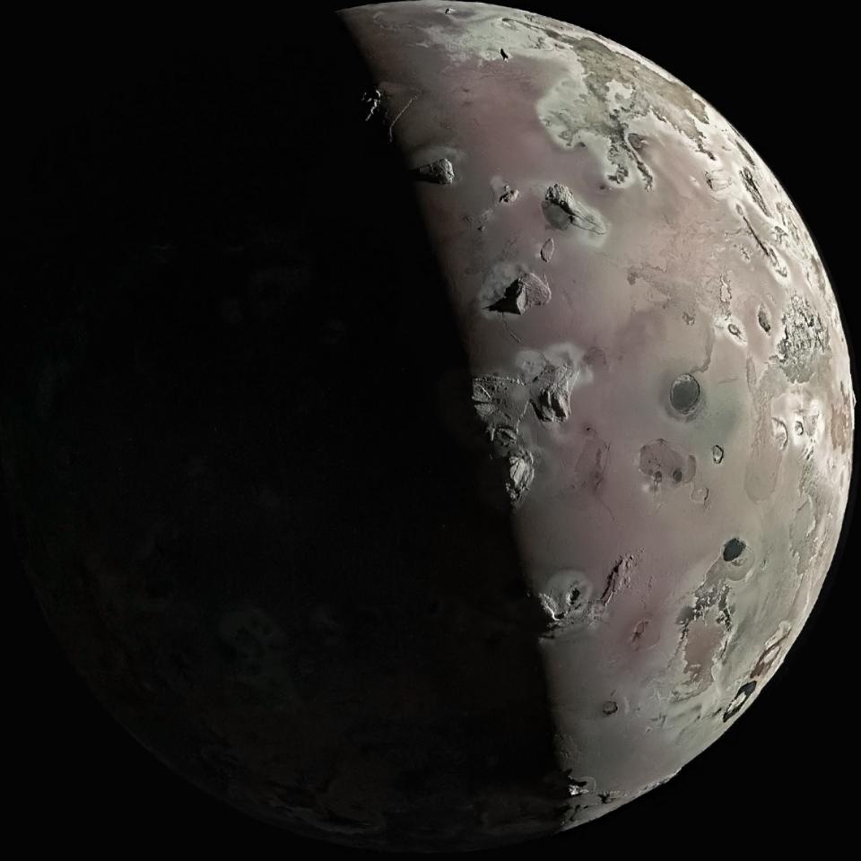 Artists composite of Jupiters moon Io taken at lowest altitude with adjustments to color temperature tint and sharpness The moon appears soft pink with a vertical shadow line through the middle